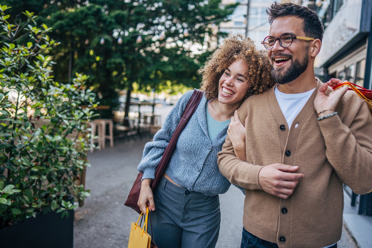 Man and woman walking outside with shopping bags