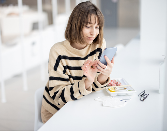 woman eating lunch checking her phone