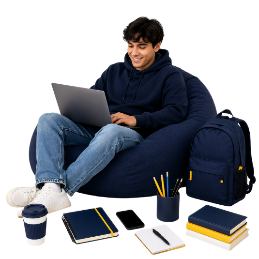 Student seated in a navy beanbag chair using a laptop, surrounded by study essentials including a backpack, notebooks, books, a smartphone, pencils, and a coffee cup.
