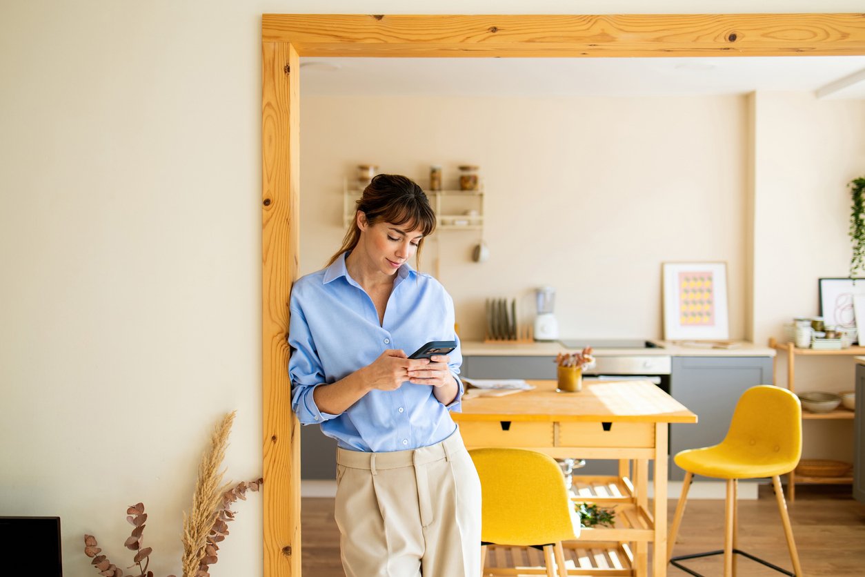 woman at home checking mobile phone