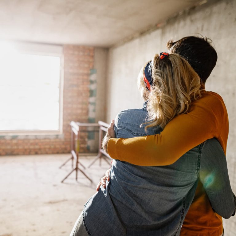 Happy couple pointing to a home renovation.