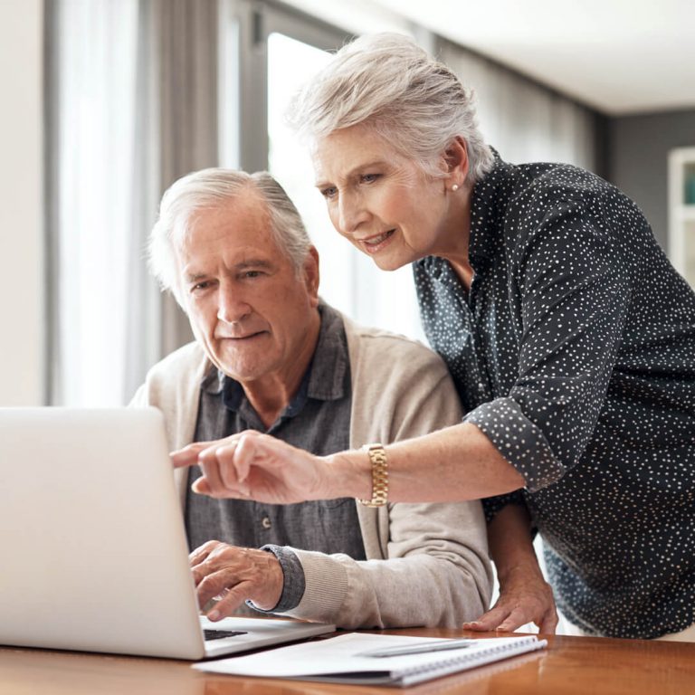 Elderly couple on computer reviewing AD&D insurance options.
