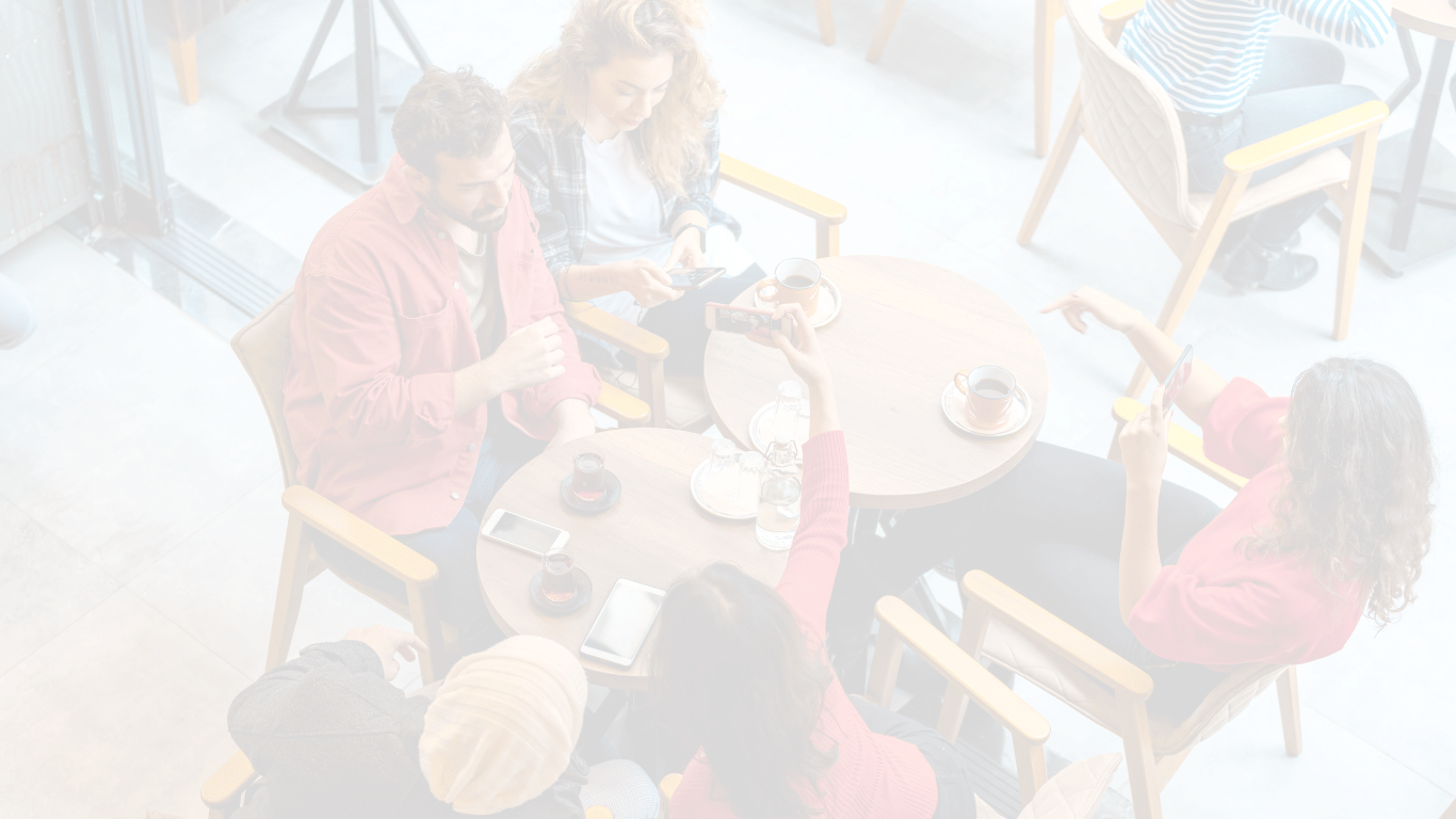 A group of people sitting around a table at a cafe.