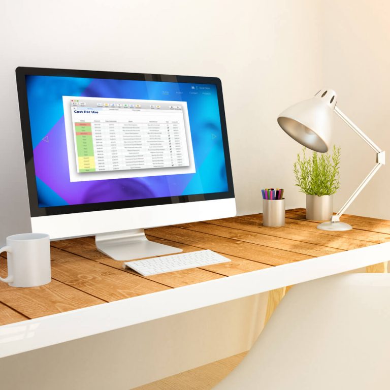 Desk with a computer monitor: "Cost Per Use" spreadsheet on screen.