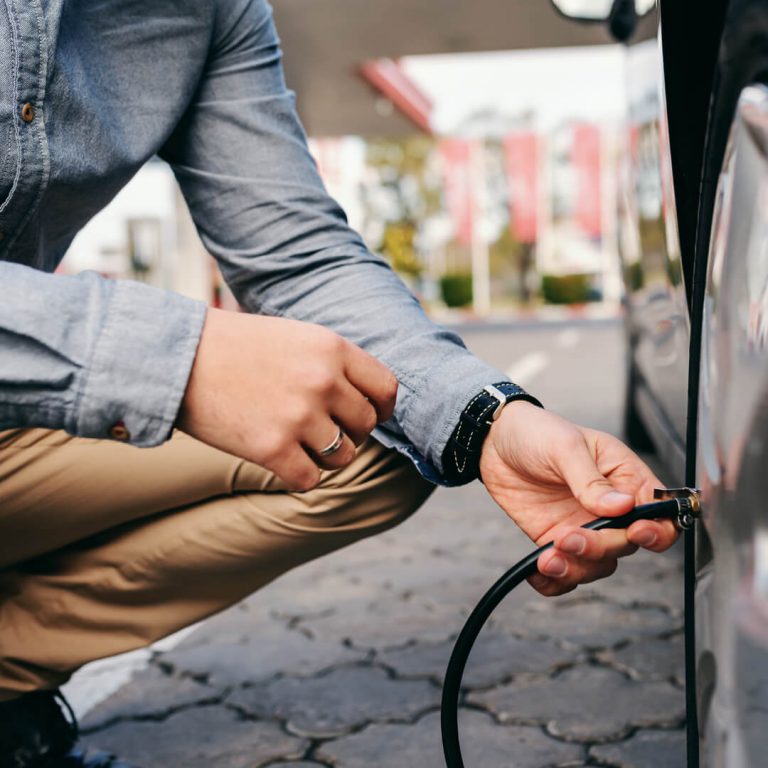 Man inflating his car tire.