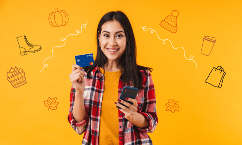 A young woman with long hair wearing a plaid shirt checks out her digital wallet while holder her Quorum Debit Card.