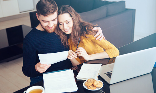 Smiling man and woman looking over their finances.
