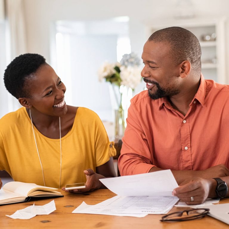 Man and woman seated together reviewing their finances.
