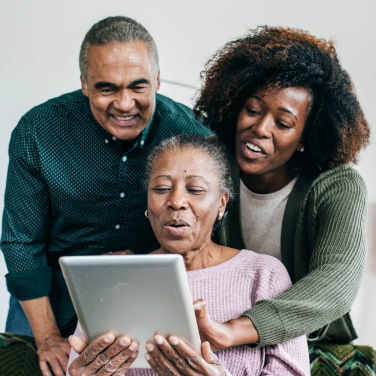 Older couple helping mother on computer, protecting her from fraud.