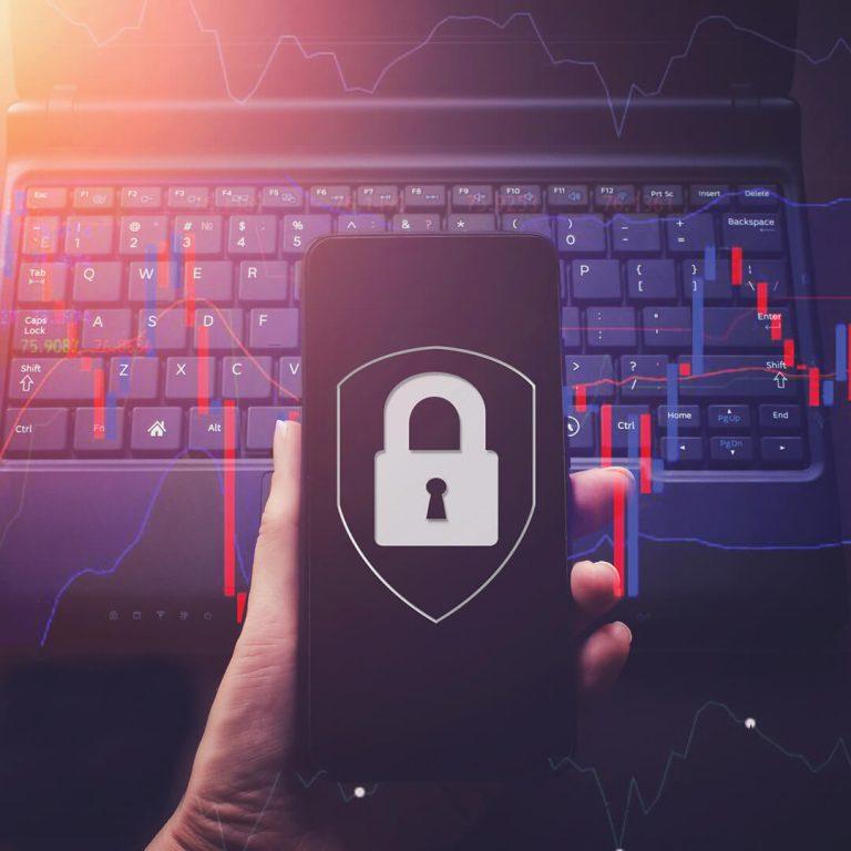 Phone displaying padlock, computer keyboard in background; concept of mobile phone security/safety.