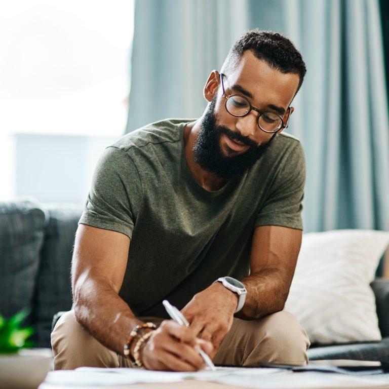 Man sitting on couch confidently handling his finances and inheritance.