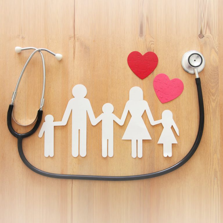 Paper cutout of family with hearts, a real stethoscope surrounding the cutouts.