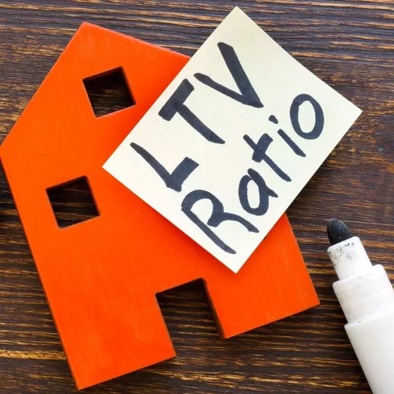 Table with red house and post-it note that says "LTV Ratio" on it.