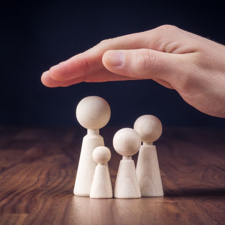 Conceptual image of hand protecting family, illustrating life insurance