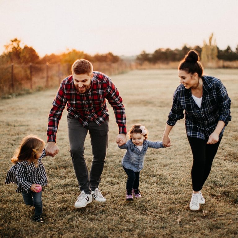 Happy family of four, playing outside.
