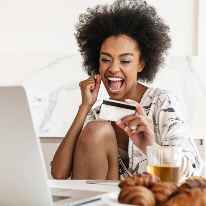 A young woman is excited to see how much money she can save by transferring other credit card balances to her Quorum Mastercard.