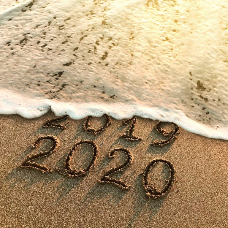 Beach shoreline - tide erasing "2019" and leaving the words "2020."