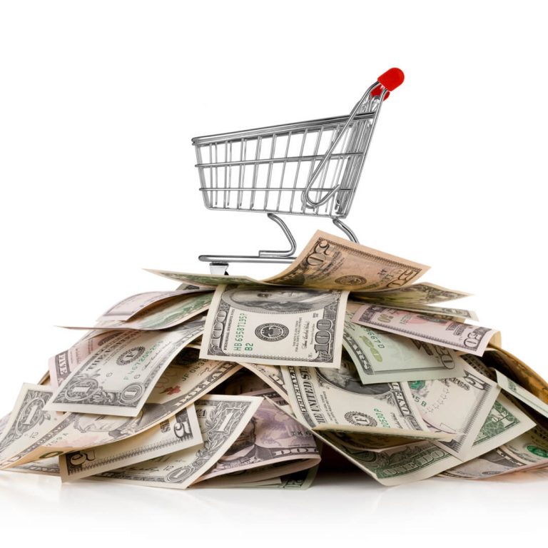 Grocery shopping cart on top of a pile of saved money.