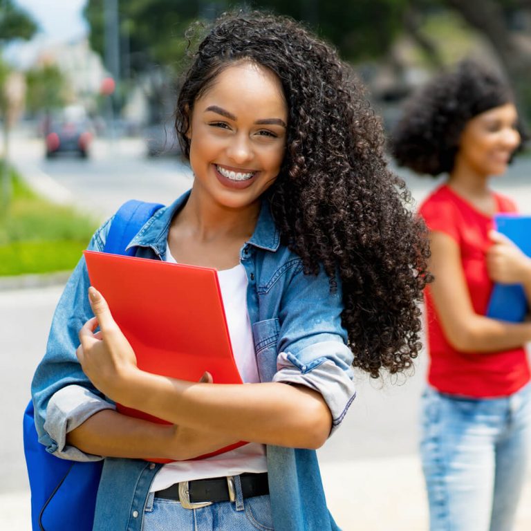 Smiling college student looking at the camera, on campus.