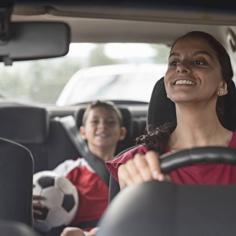 Mother driving young son to soccer practice.