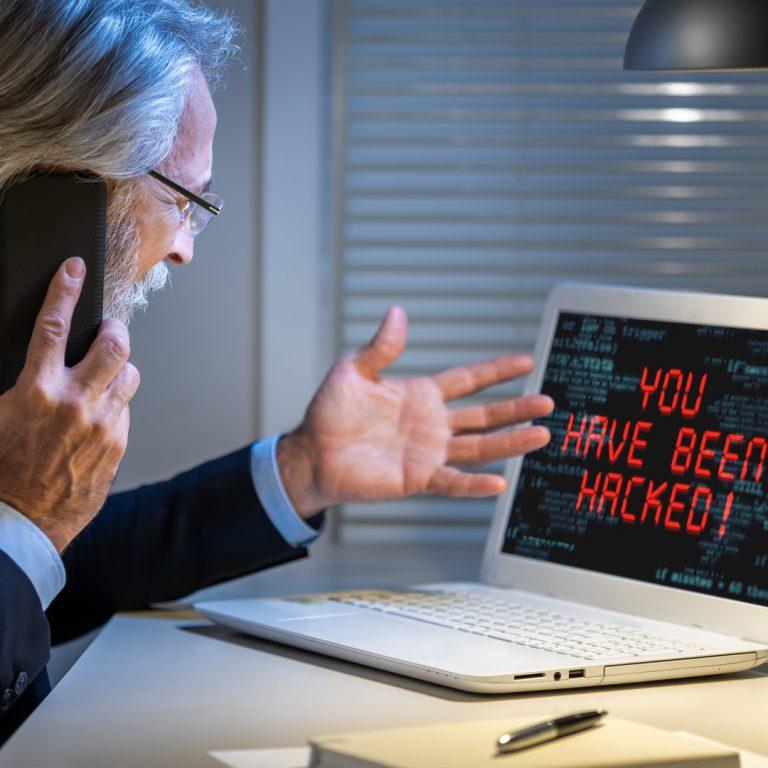 Man on phone with technical support scammer after receiving popup on his computer.