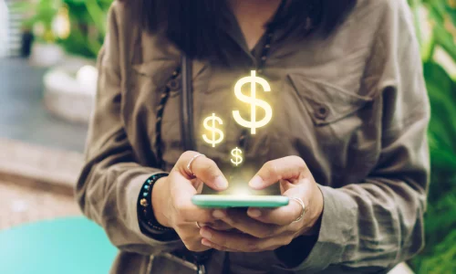 A woman eagerly checks her cell phone for her HighQ savings balance.