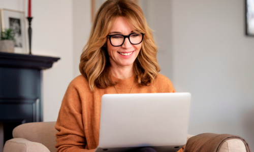 Woman with glasses at home working on her computer.