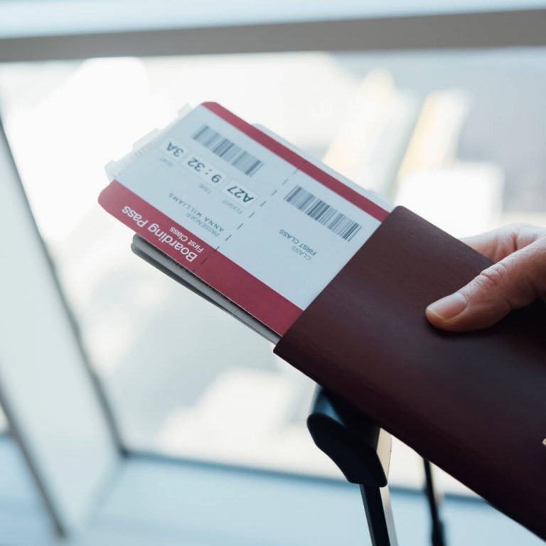 Closeup of airline tickets in a person's passport (airline tickets are a great buy in September.)