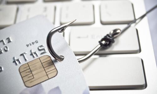 A fishing hook caught to a credit card, illustrating credit card fraud.
