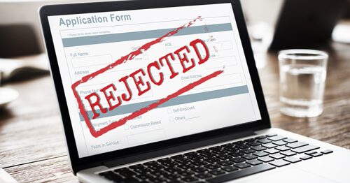 An application on a computer screen with the words REJECTED across it in red.