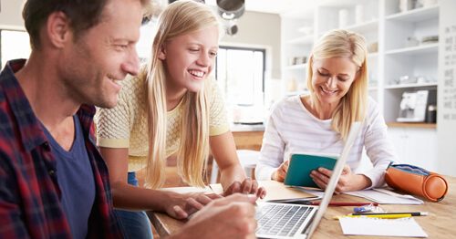 Parents sitting with teenage daughter teaching her about finances.