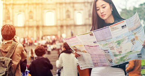 Young woman traveling in Rome, holding a map.