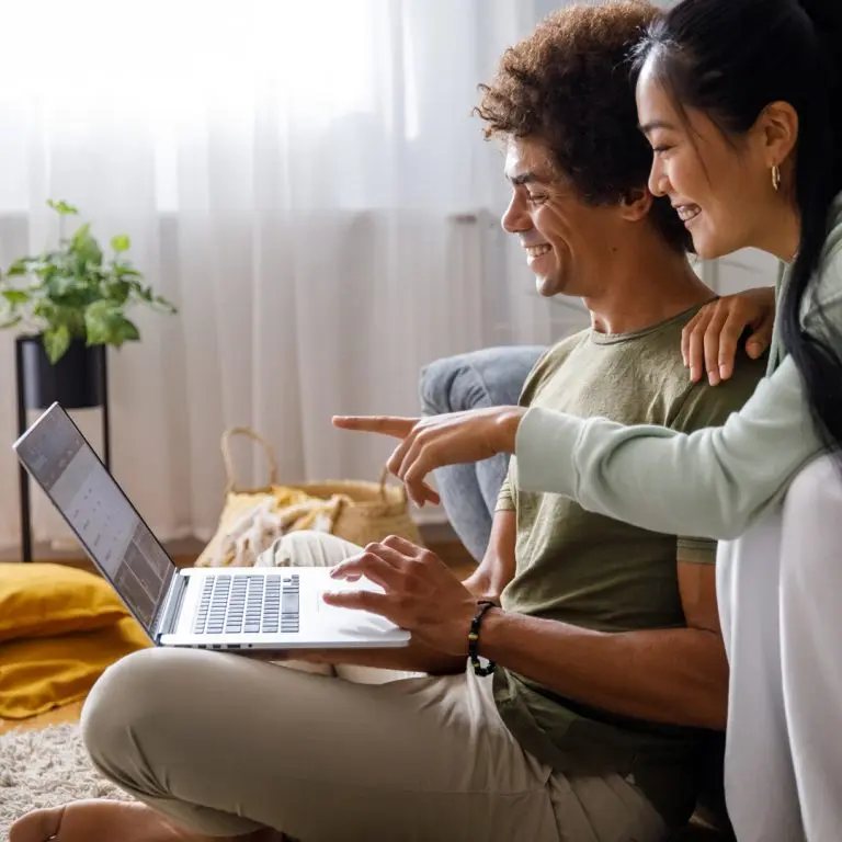 Couple opening up a free checking account online, smiling.
