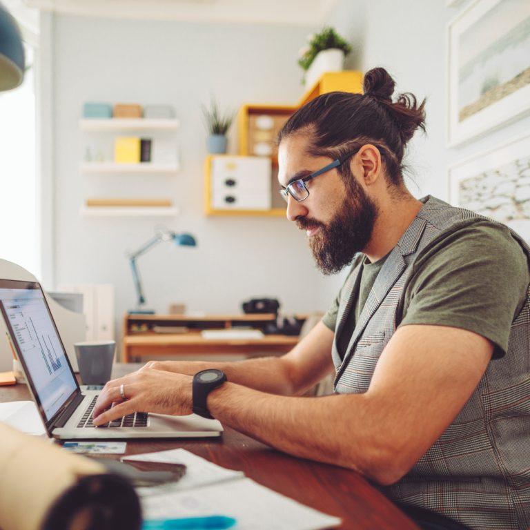 Freelancer doing his taxes at home at his desk.