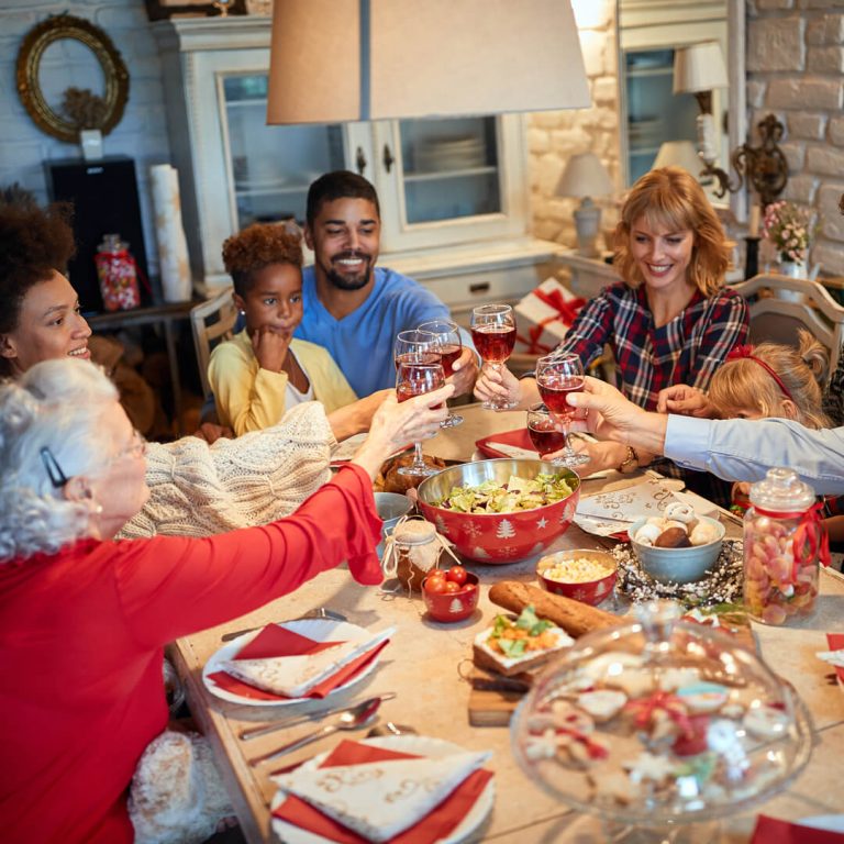 Family gathered around holiday table, smiling and enjoying meal.