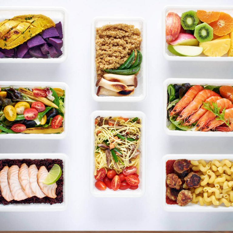 Portioned-out meals against a white background, illustrating meal planning and prepping.
