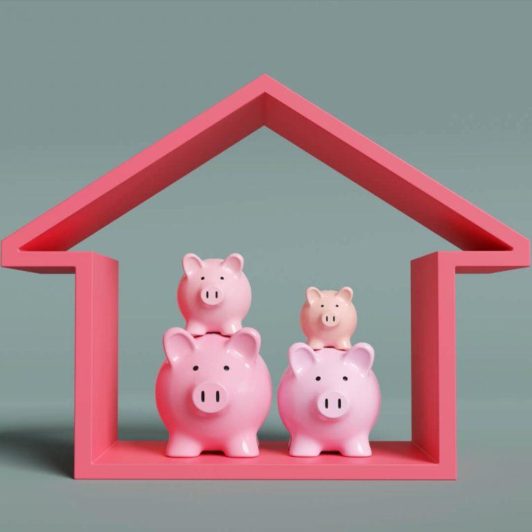 Toy pigs in house, illustrating concept of a piggyback mortgage.