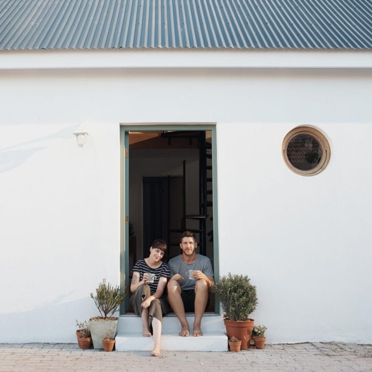 Couple sitting outside of their rental home.