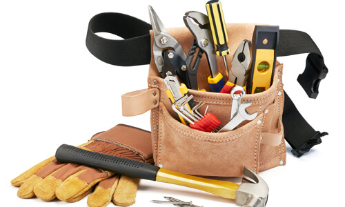 A variety of home improvement tools with tool belt on white background.