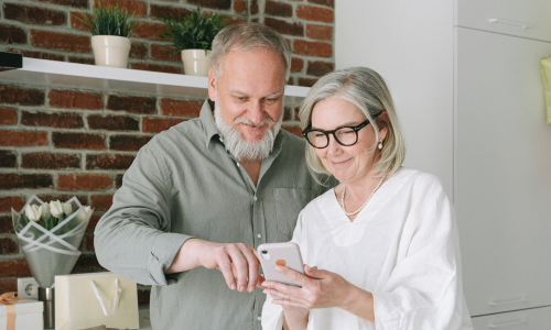 Couple at home looking at computer.