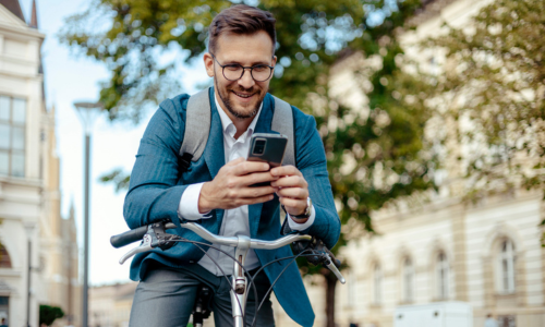 Man riding bike in the city looking at phone