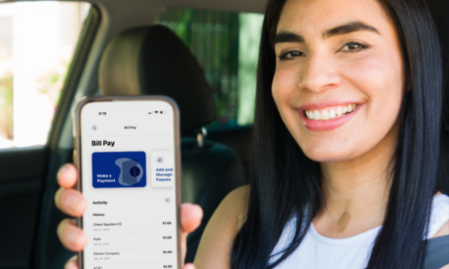 Woman in car using her mobile banking app to pay bills.