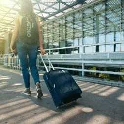 Woman Walking Through Airport With Bag